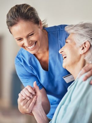 Shot of a young caregiver caring for her elderly patient in her home